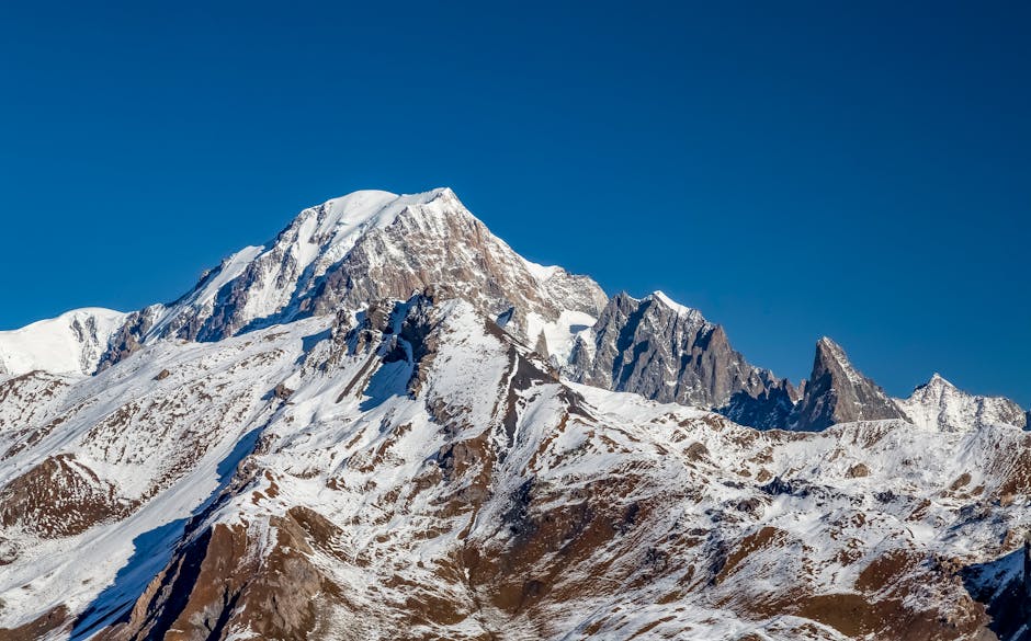 Majestic snow-covered mountain summit under clear blue sky