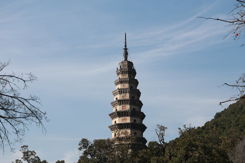 A stunning ancient pagoda tower amidst nature with a clear blue sky backdrop.